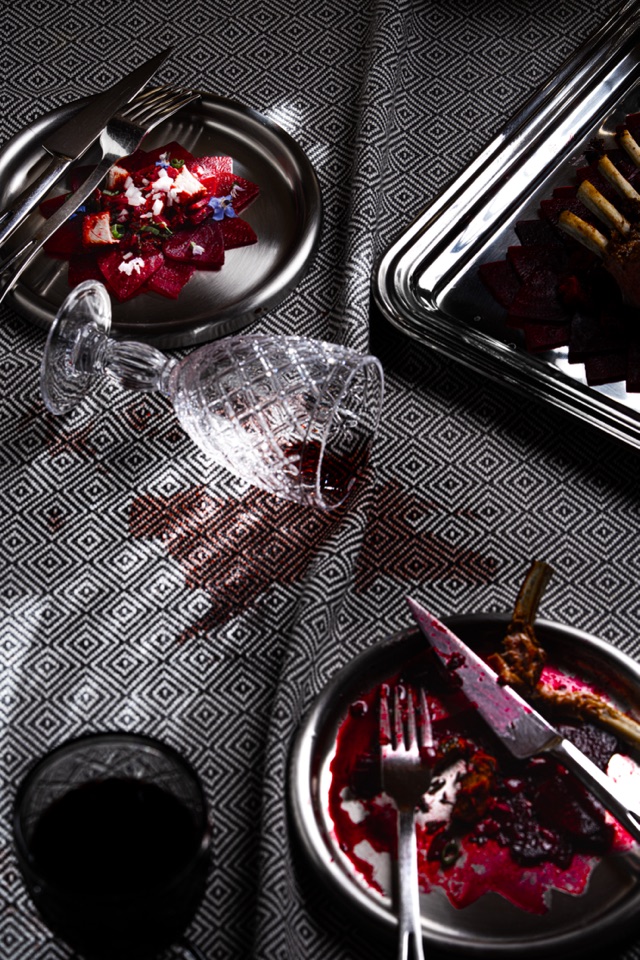 Table rouge et noire avec assiettes de betteraves et verre renversé